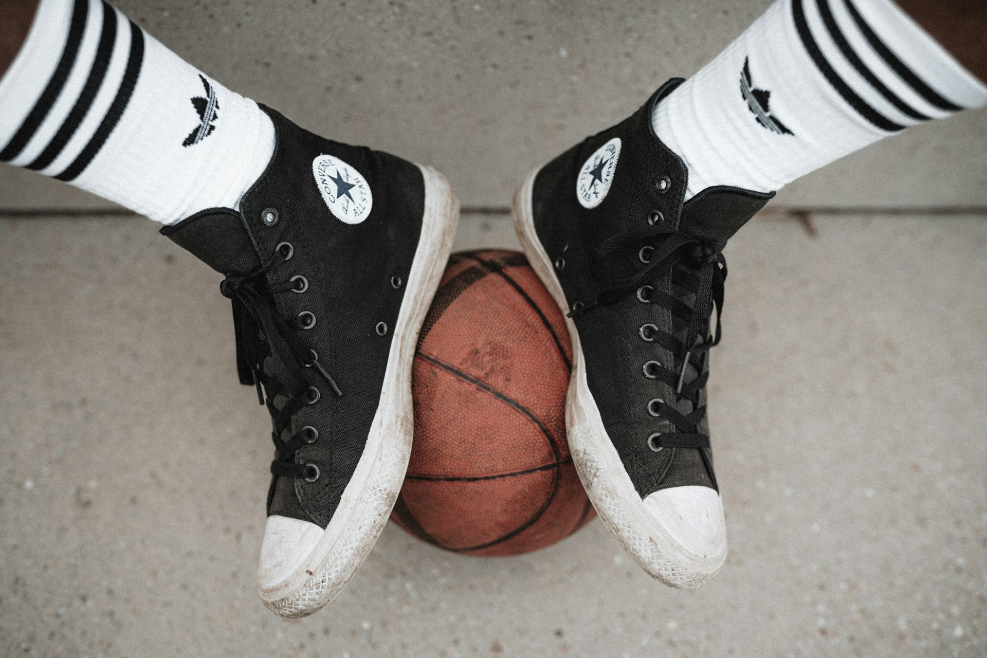 person wearing black and white converse all star high tops